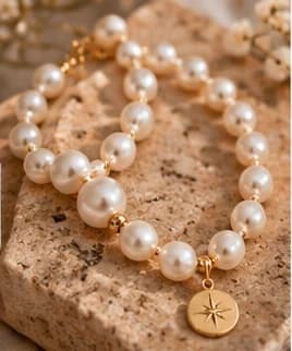 Pearl bracelet with a star medallion on travertine